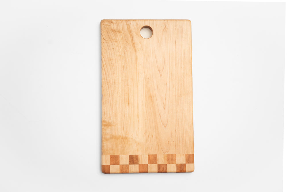 Walnut cutting board with checkered inlay used as charcuterie board