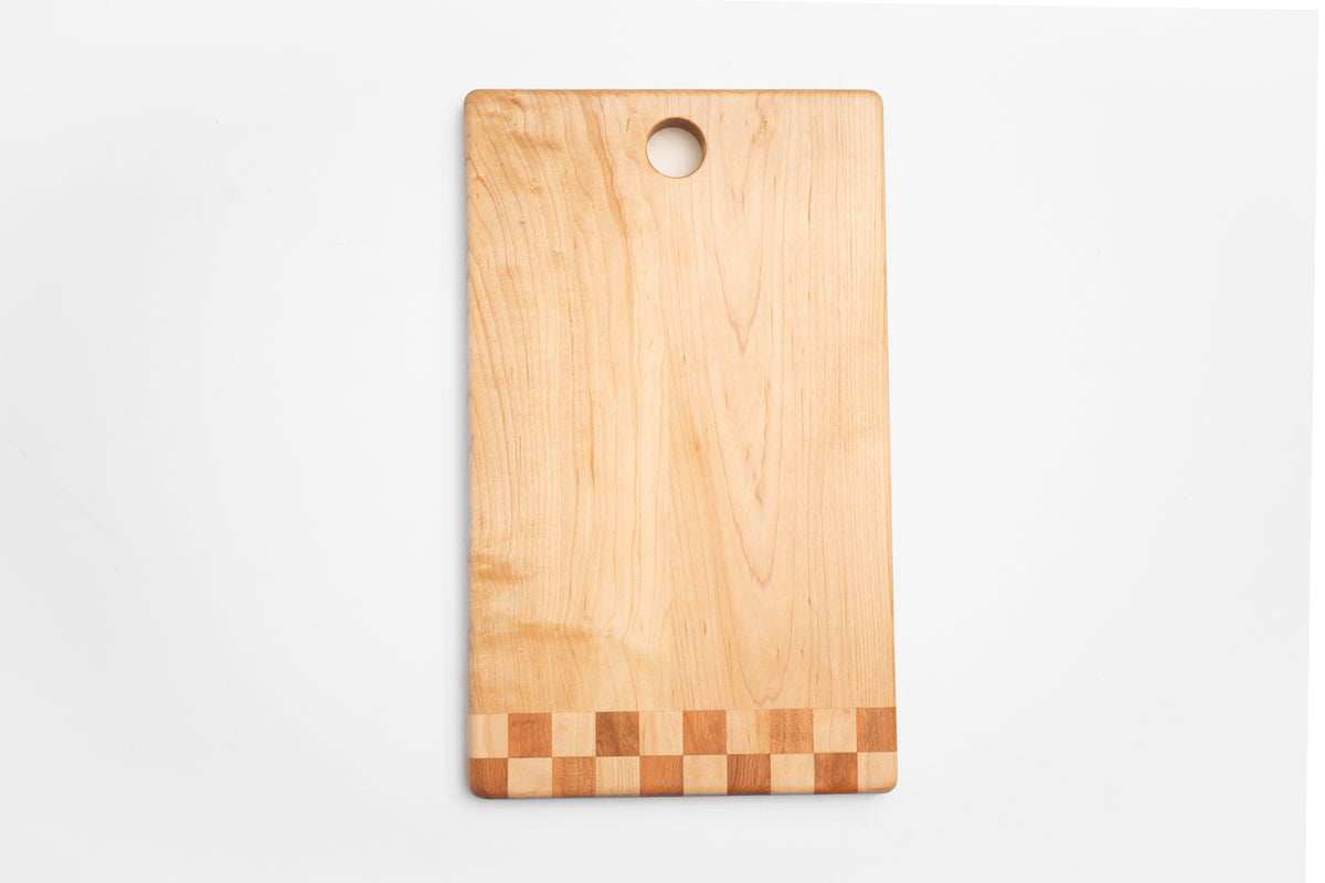 Walnut cutting board with checkered inlay used as charcuterie board