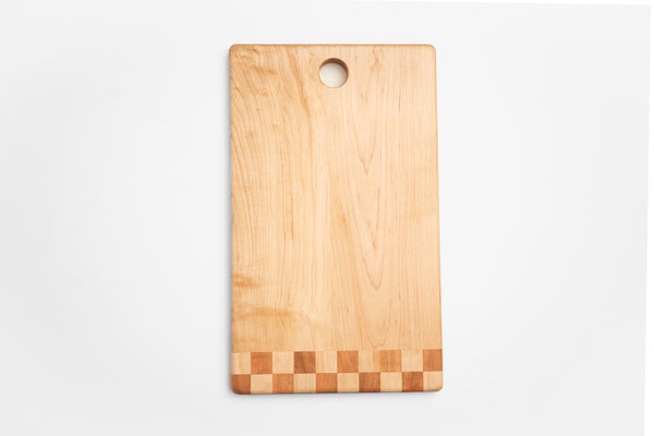Walnut cutting board with checkered inlay used as charcuterie board