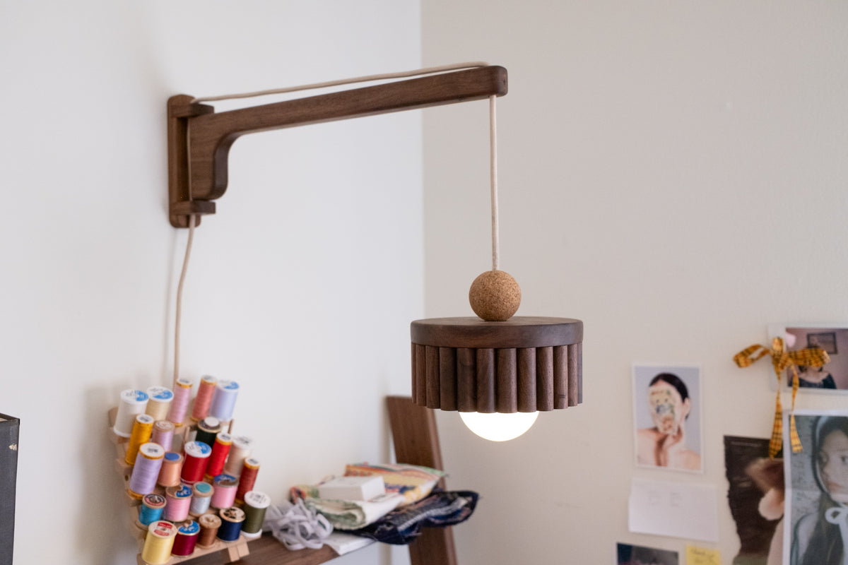 Swing arm wall pendant light turned on showing warm light