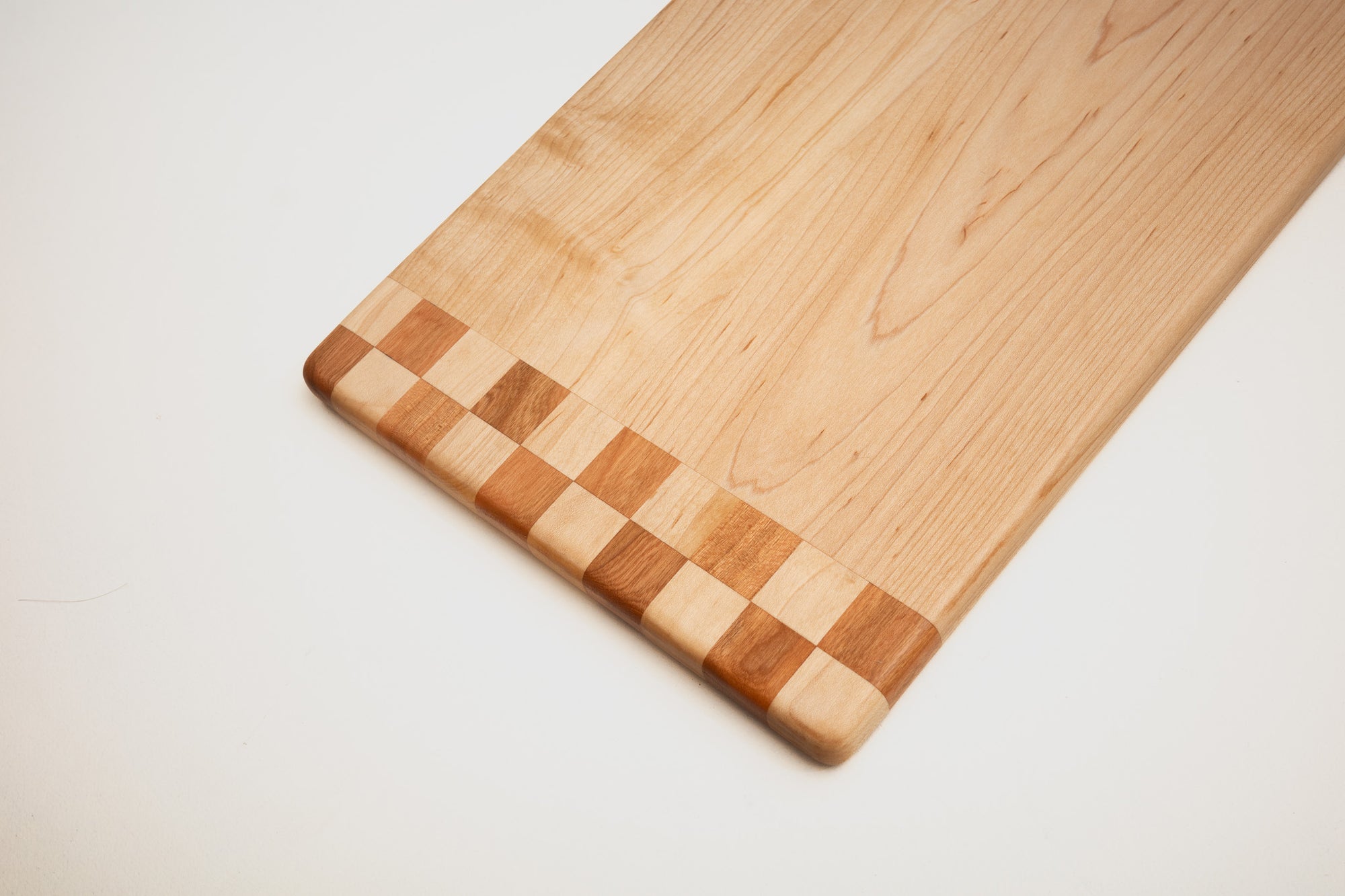 Maple and walnut cutting board on kitchen counter