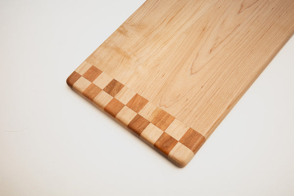 Maple and walnut cutting board on kitchen counter