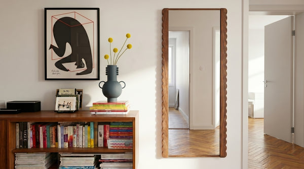 Scallop mirror leaning against wall in modern bedroom
